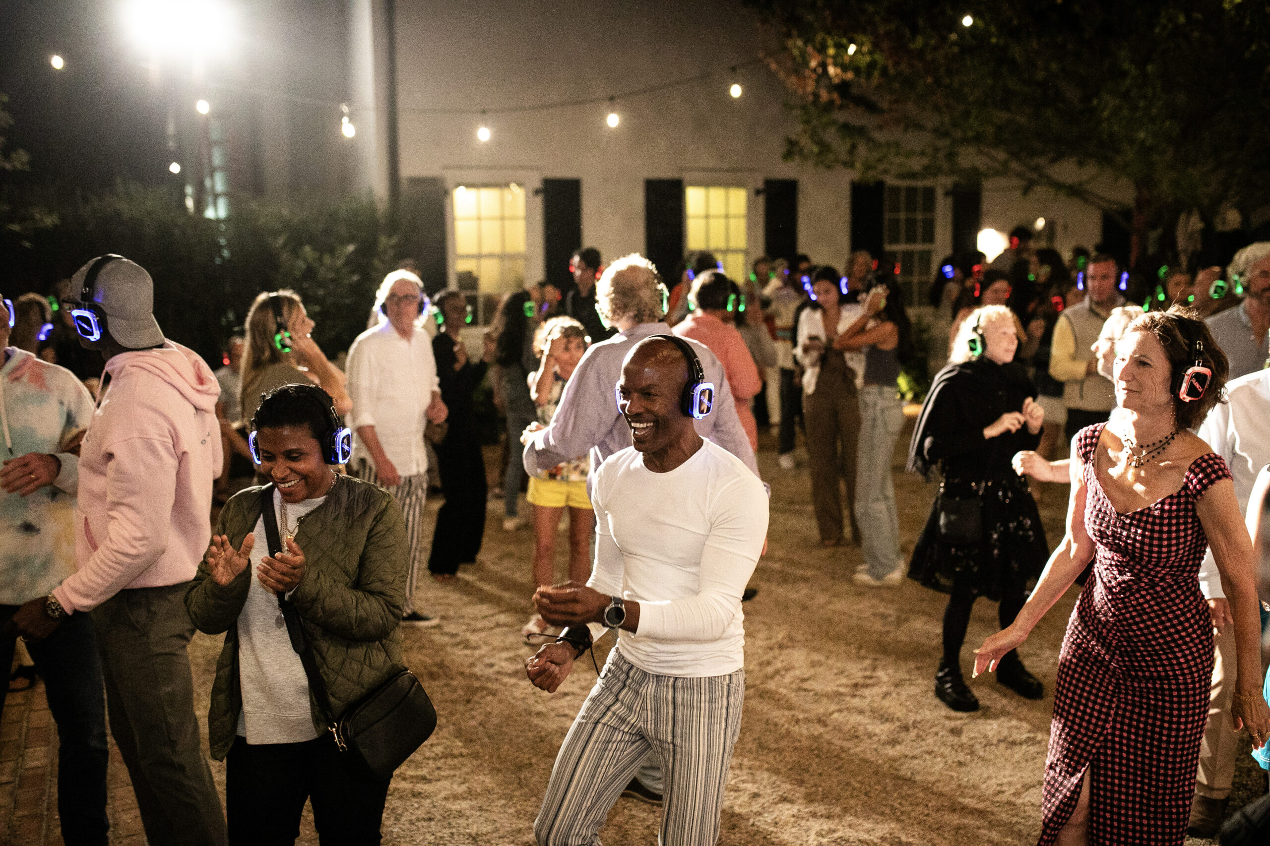 Outdoor DFW silent disco with LED headphones, normal clothes, string lights